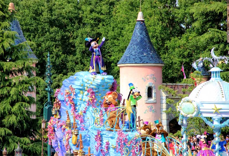 Micky Mouse atop a float at a parade in Disneyland Paris